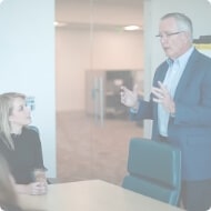 John Morris standing up and speaking with a client who is sitting down