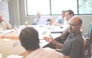 People sitting down at a table in a meeting